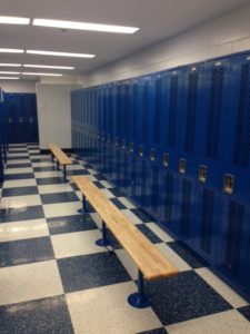 tall blue lockers in locker room with benches