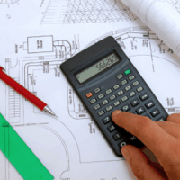 Person using calculator while creating blueprints