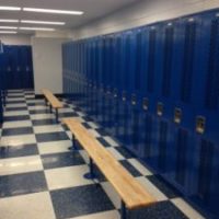 tall blue lockers in locker room with benches