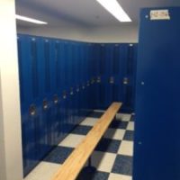 long bench with tall blue lockers in locker room